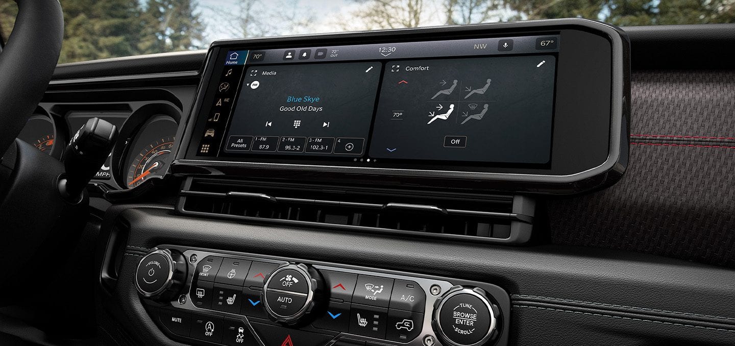 Display The Uconnect touchscreen in the 2024 Jeep Gladiator, with an audio selection and climate controls displayed on the touchscreen.