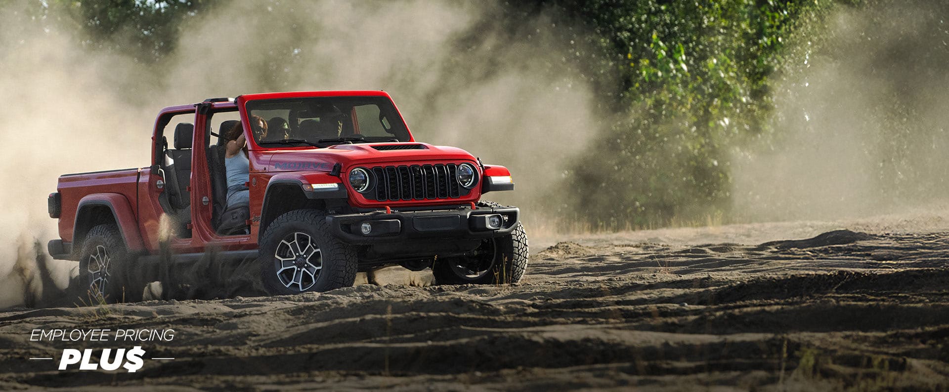 A red 2024 Jeep Gladiator Rubicon X with its doors and roof removed, traveling on a sandy trail off-road. Employee Pricing Plus Event.