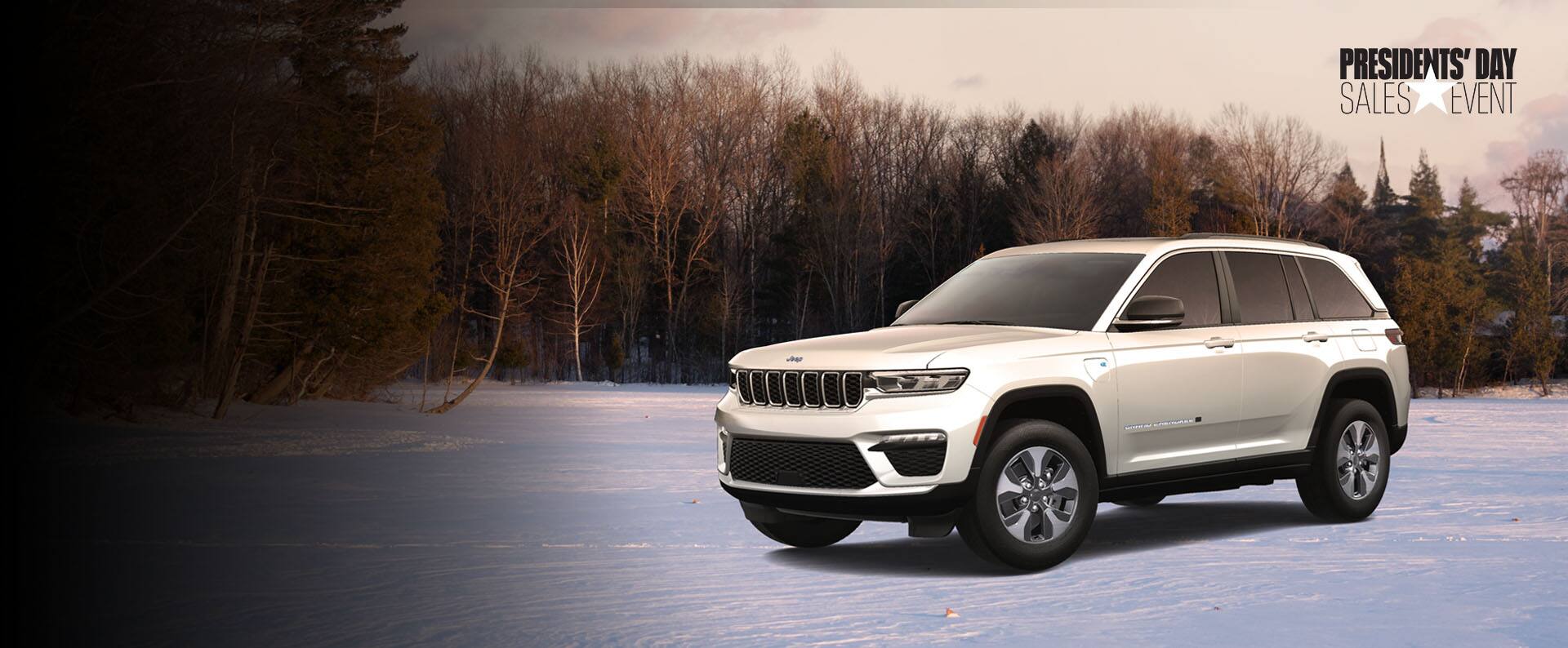 An angled passenger-side profile of a white 2024 Jeep Grand Cherokee Summit Reserve 4xe parked on a snow-covered trail, with trees in the background. Jeep. Presidents' Day Sales Event logo.