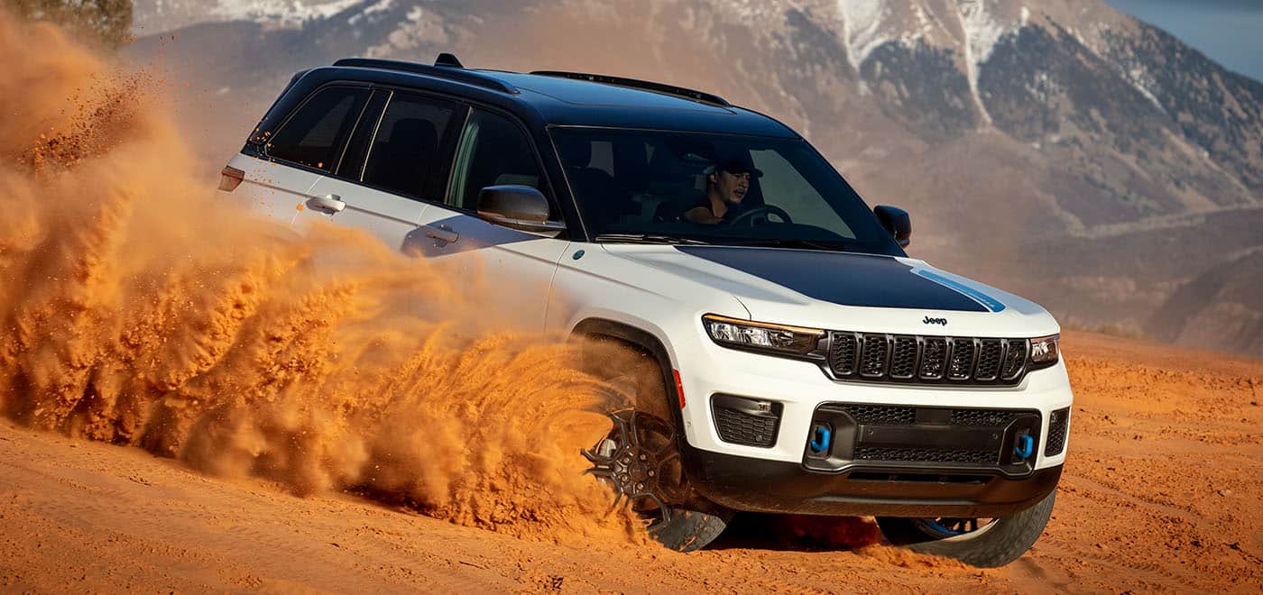 2024 Two toned black and white with blue accents Jeep Grand Cherokee 4XE jumping sand dunes