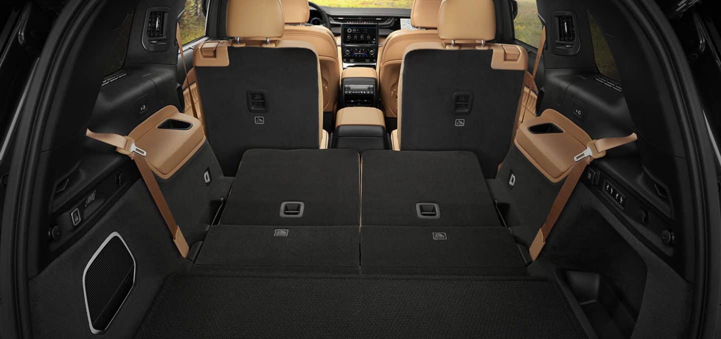Display The cargo area of a 2024 Jeep Grand Cherokee L Summit Reserve with the second- and third-row seats folded down, demonstrating the large cargo area.