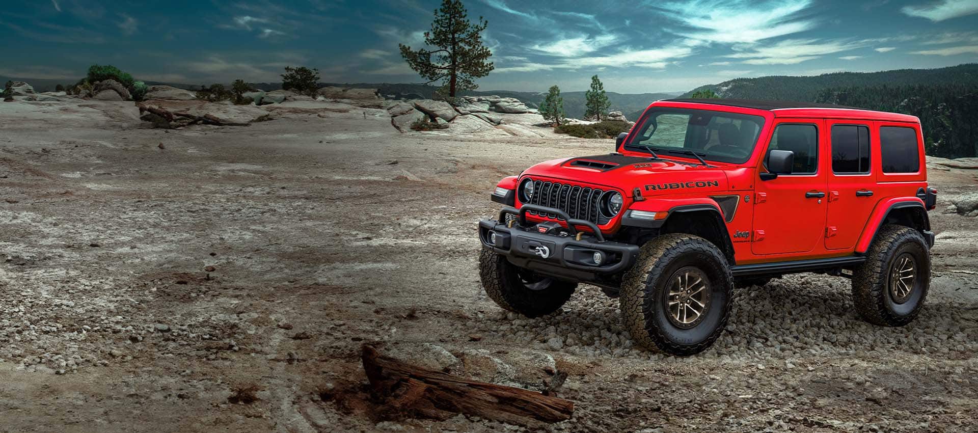 Red Jeep Rubicon parked on a mountain in a forrest 