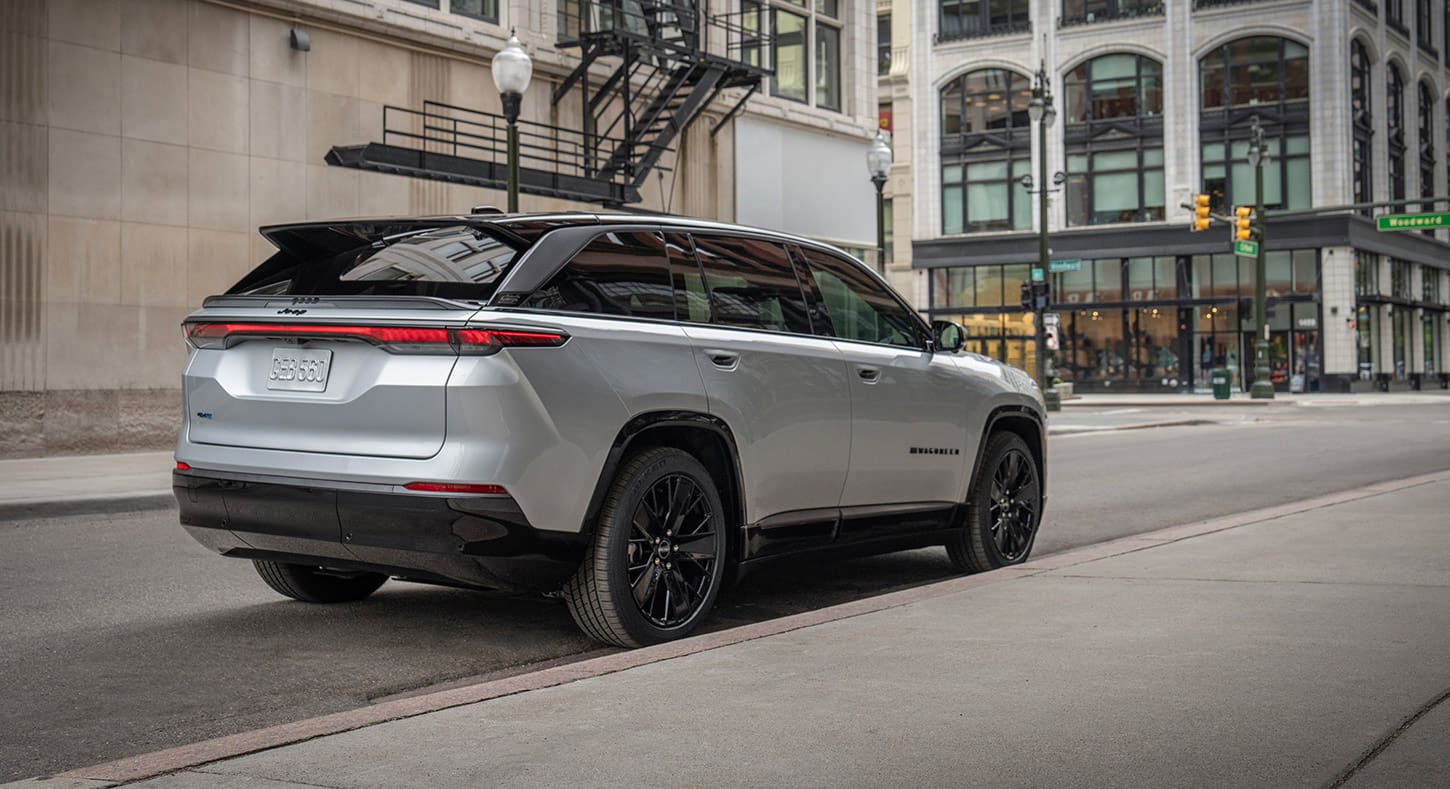 Ángulo trasero del lado del pasajero de un Jeep Wagoneer S Launch Edition ​​​​​​​2024 plateado estacionado en un distrito comercial.