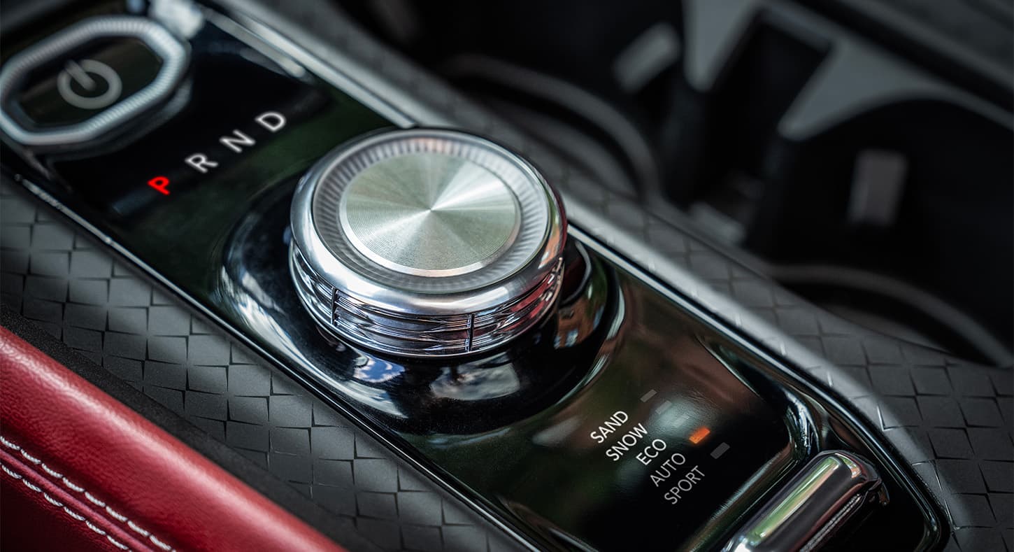 Primer plano del selector de modo de manejo del sistema de control de tracción Selec-Terrain en el Jeep Wagoneer S Launch Edition 2024, con modos arena, nieve, ecológico, automático y deportivo.