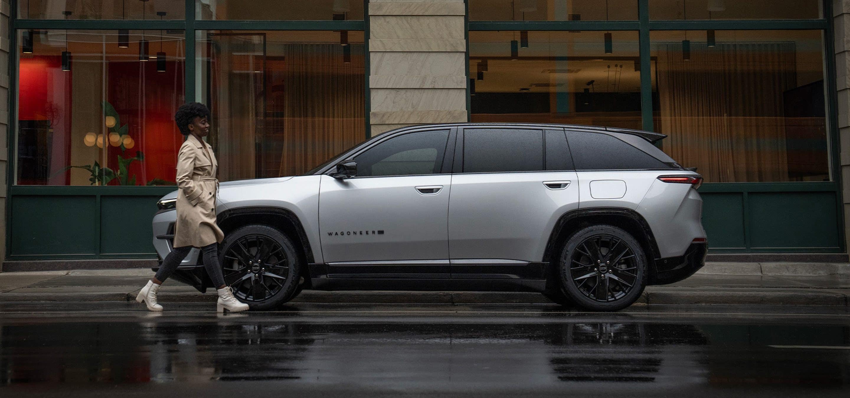 2024 Jeep Wagoneer S in Silver Zynith parked on city street on rainy day.