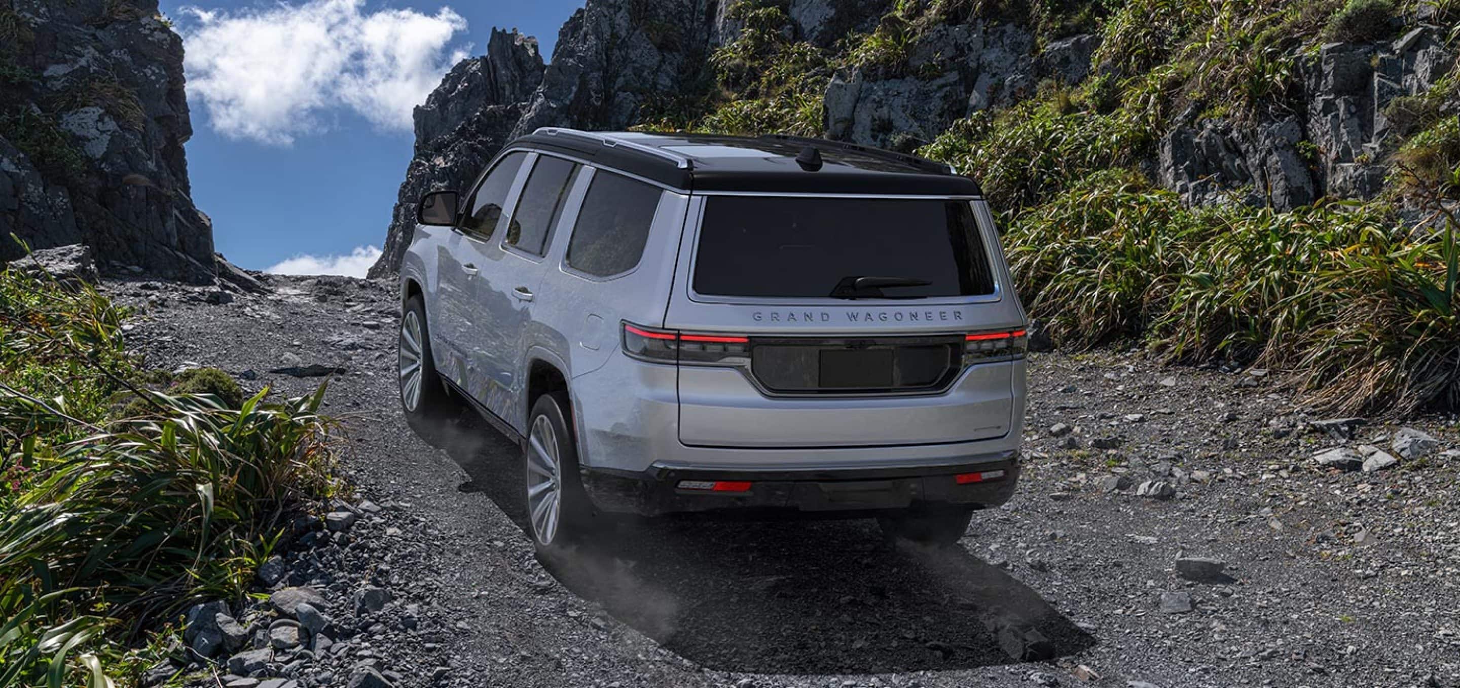 2024 jeep grand wagoneer going up gravel path by mountains. 