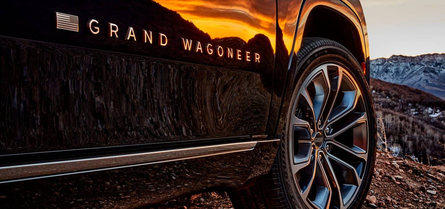 Display A close-up of the wheel, tire and Grand Wagoneer badge on the front passenger door of the 2024 Grand Wagoneer Series III.