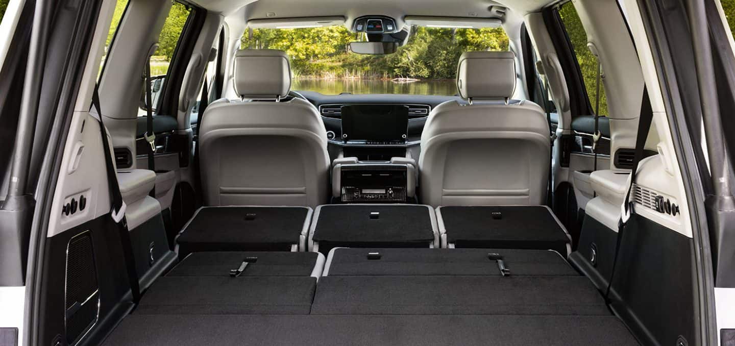 Display The interior of the 2024 Wagoneer Series III with the second- and third-row seats folded, revealing the massive cargo area.