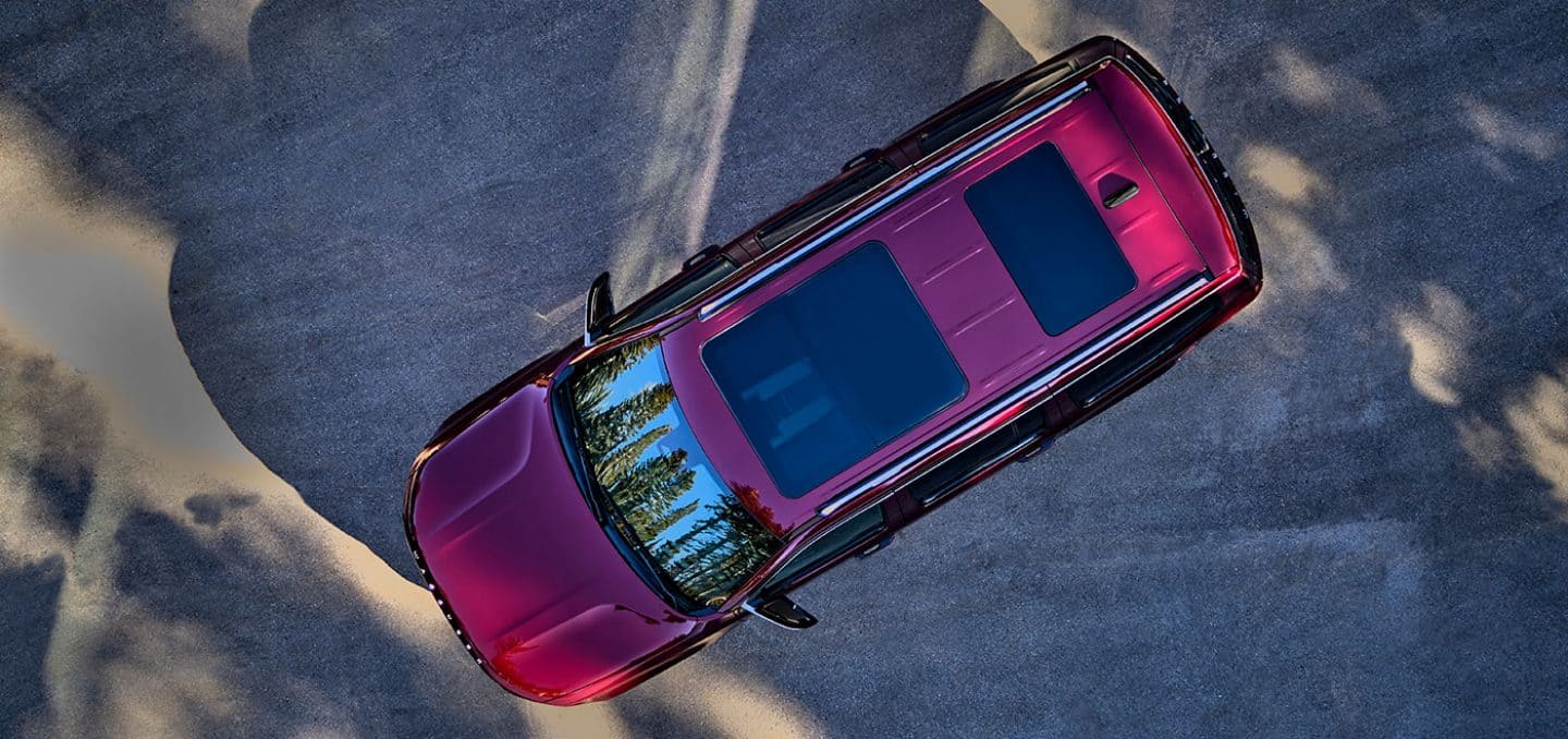 Display An overhead view of the tri-pane panoramic sunroof in a red 2024 Wagoneer Series III.