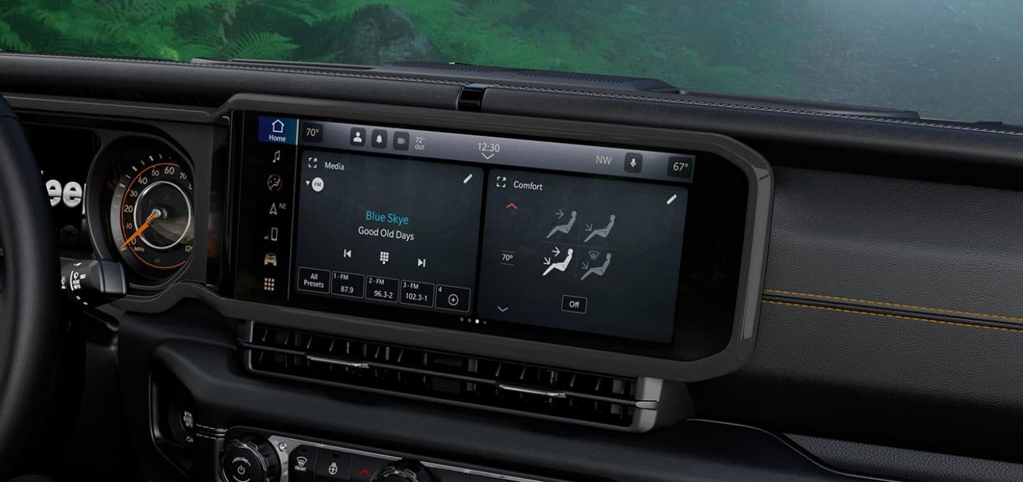 Display A close-up of the Uconnect 5 Nav touchscreen in the 2024 Jeep Wrangler with a split-screen displaying the radio selection and climate controls.