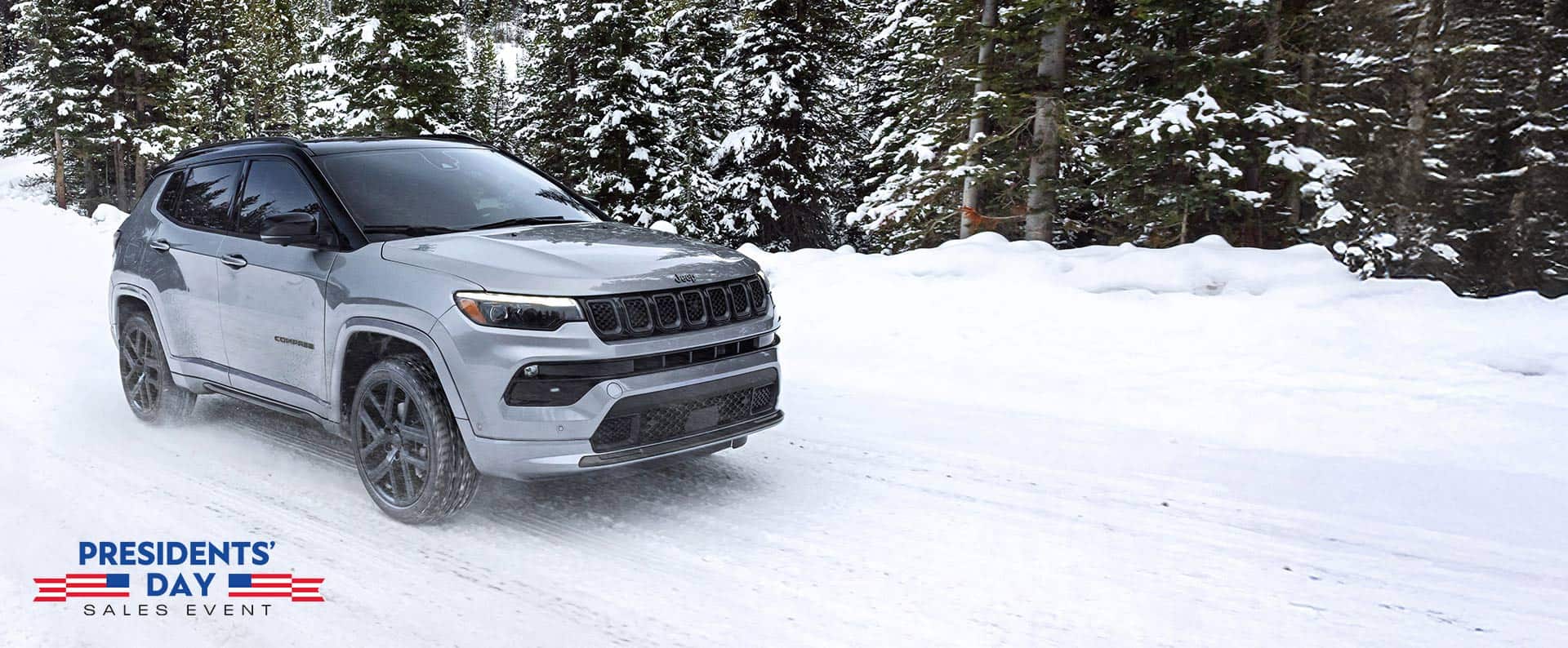 Un Jeep Compass Limited 2025 plateado con el paquete High Altitude circulando por un sendero cubierto de nieve en el bosque. El evento de ventas por el Día del Presidente.
