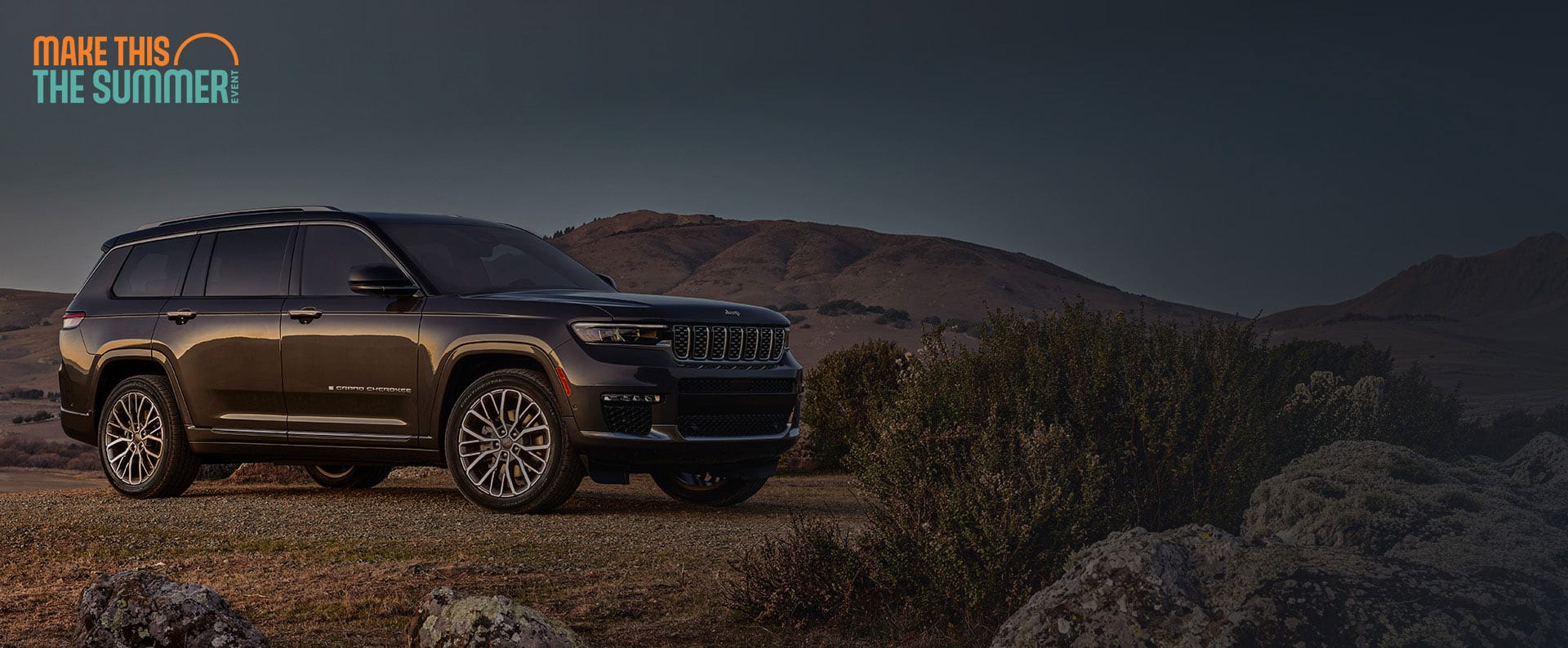 Un Jeep Grand Cherokee Summit Reserve 2025 gris oscuro estacionado en un claro fuera de la carretera, en el desierto. Conviértelo en el evento del verano.