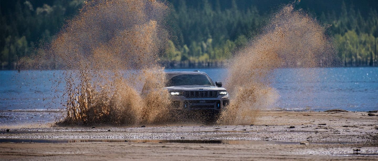 2025 Jeep Grand Cherokee Trail hawk driving through a muddy lake bed