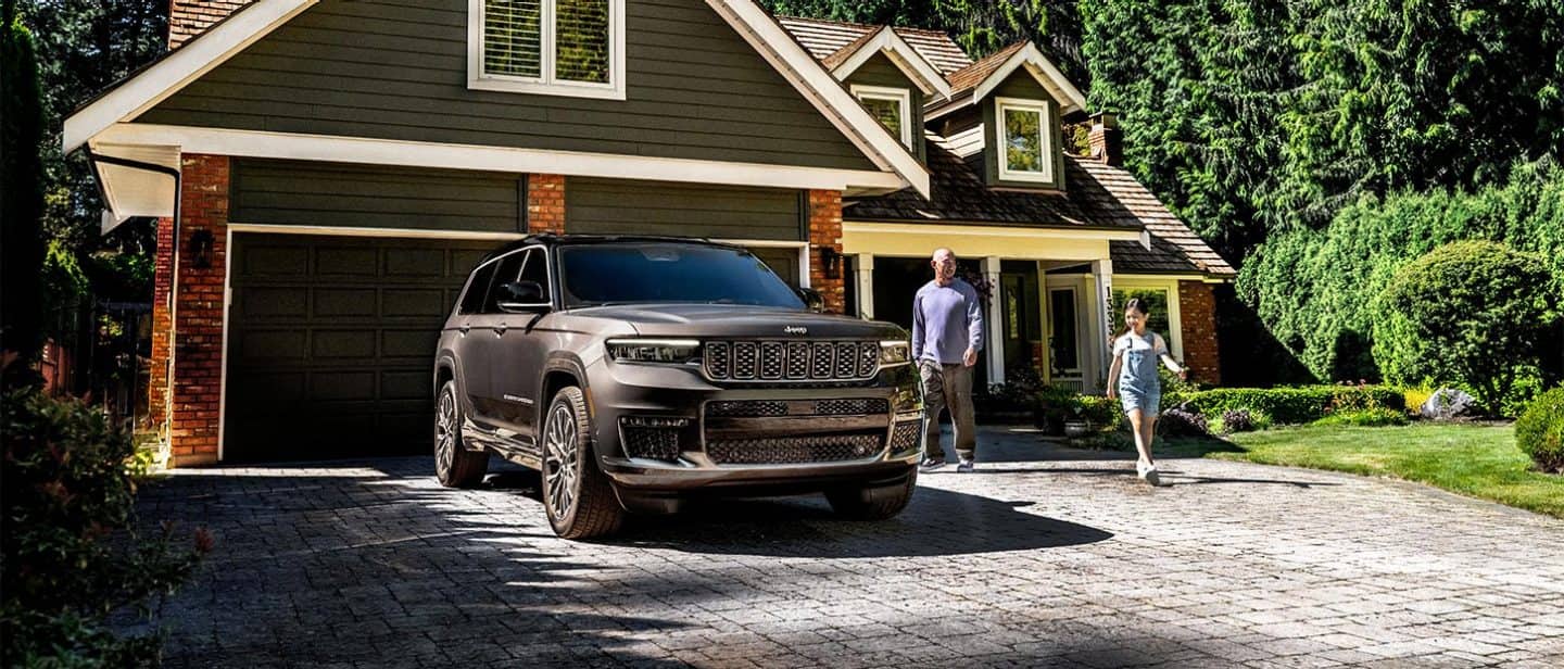 2025 Jeep Grand Cherokee Summit Reserve parked in the driveway of residential family home