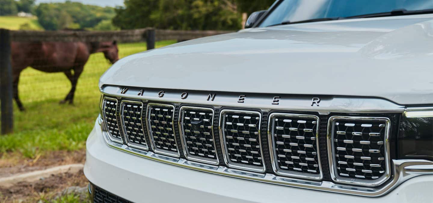 Display A close-up of the grille on a white 2025 Jeep Grand Wagoneer Series 3.