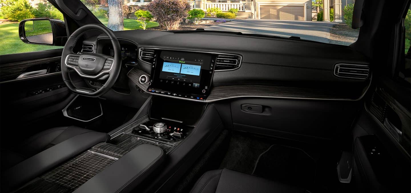 Display The front row of the 2025 Jeep Wagoneer Series III cabin, focusing on the seats, steering wheel, touchscreen and dash.