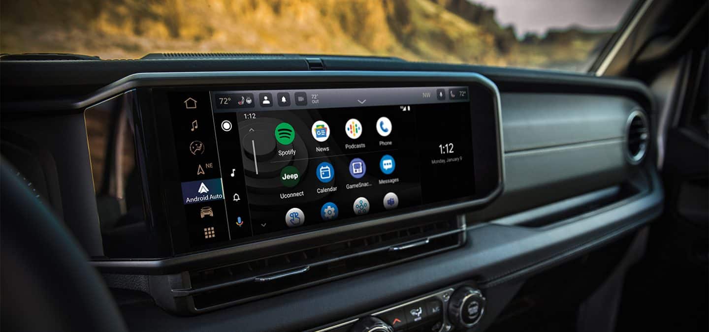 Display A close-up of the Uconnect touchscreen in the 2025 Jeep Wrangler displaying a series of Android Auto selections and the current date and time.