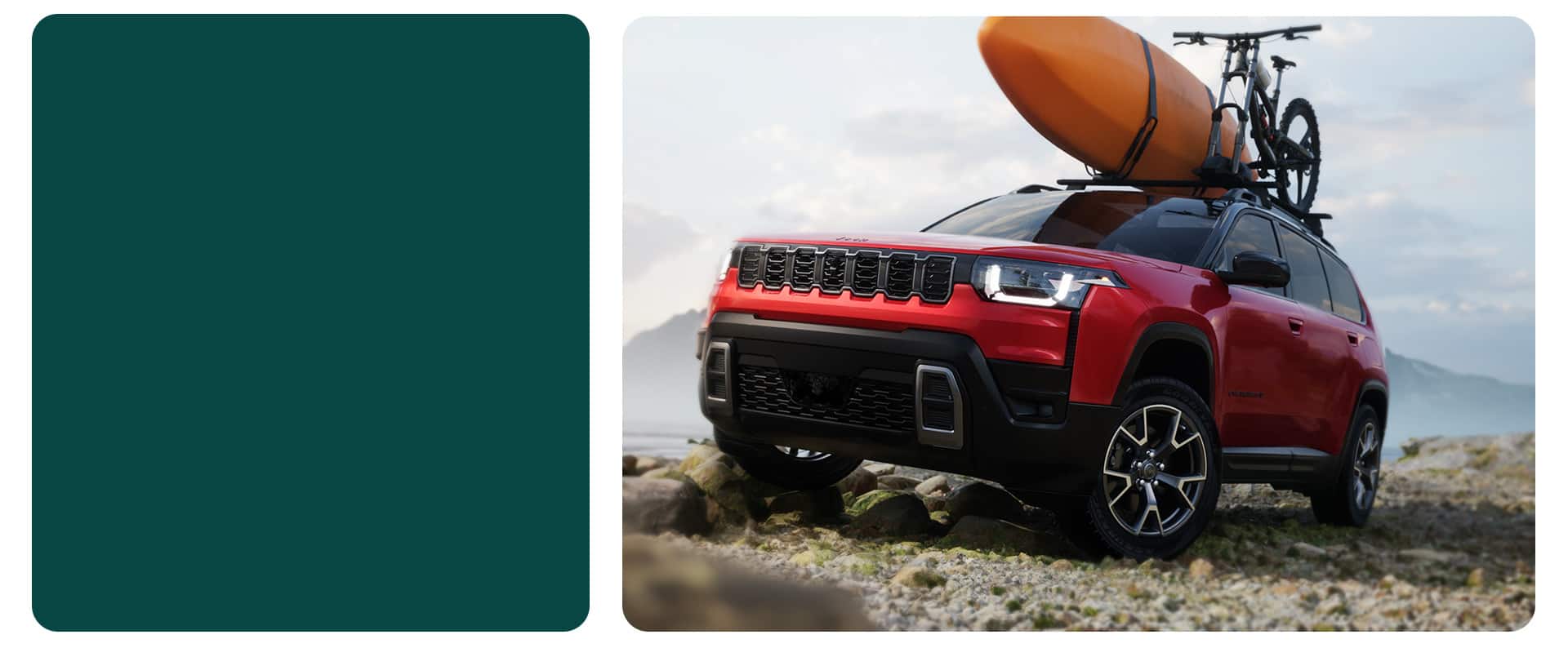 A red 2026 Jeep Cherokee Overland parked on a rocky beach with a kayak and part of a bike strapped to its roof rack.