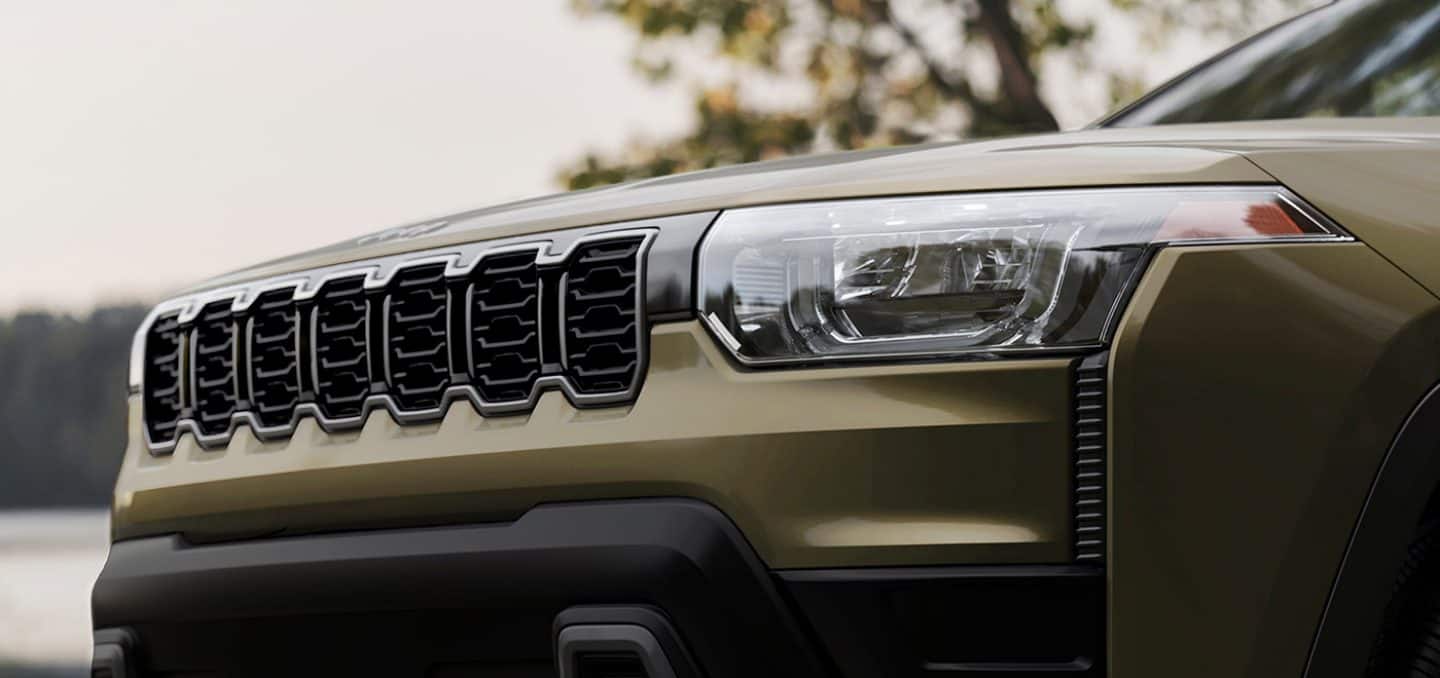 Display The grille on an olive green 2026 Jeep Cherokee.