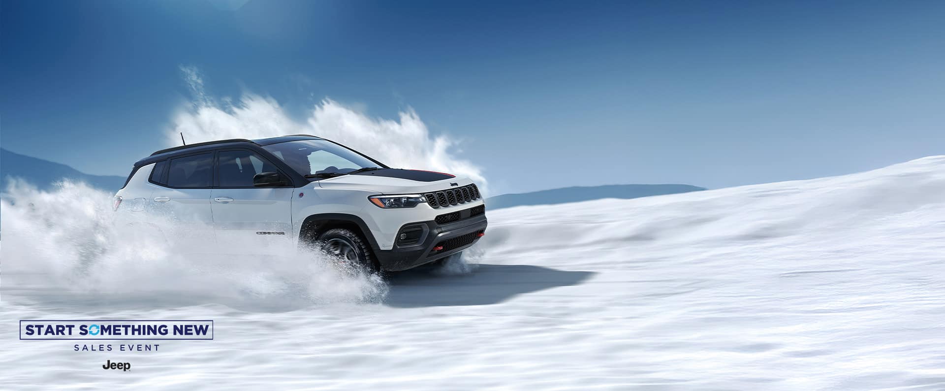 A white 2026 Jeep Compass Trailhawk with a black hood insert and black roof, traveling on a trail off-road, kicking up snow as it goes. The Start Something New Sales Event. Jeep.
