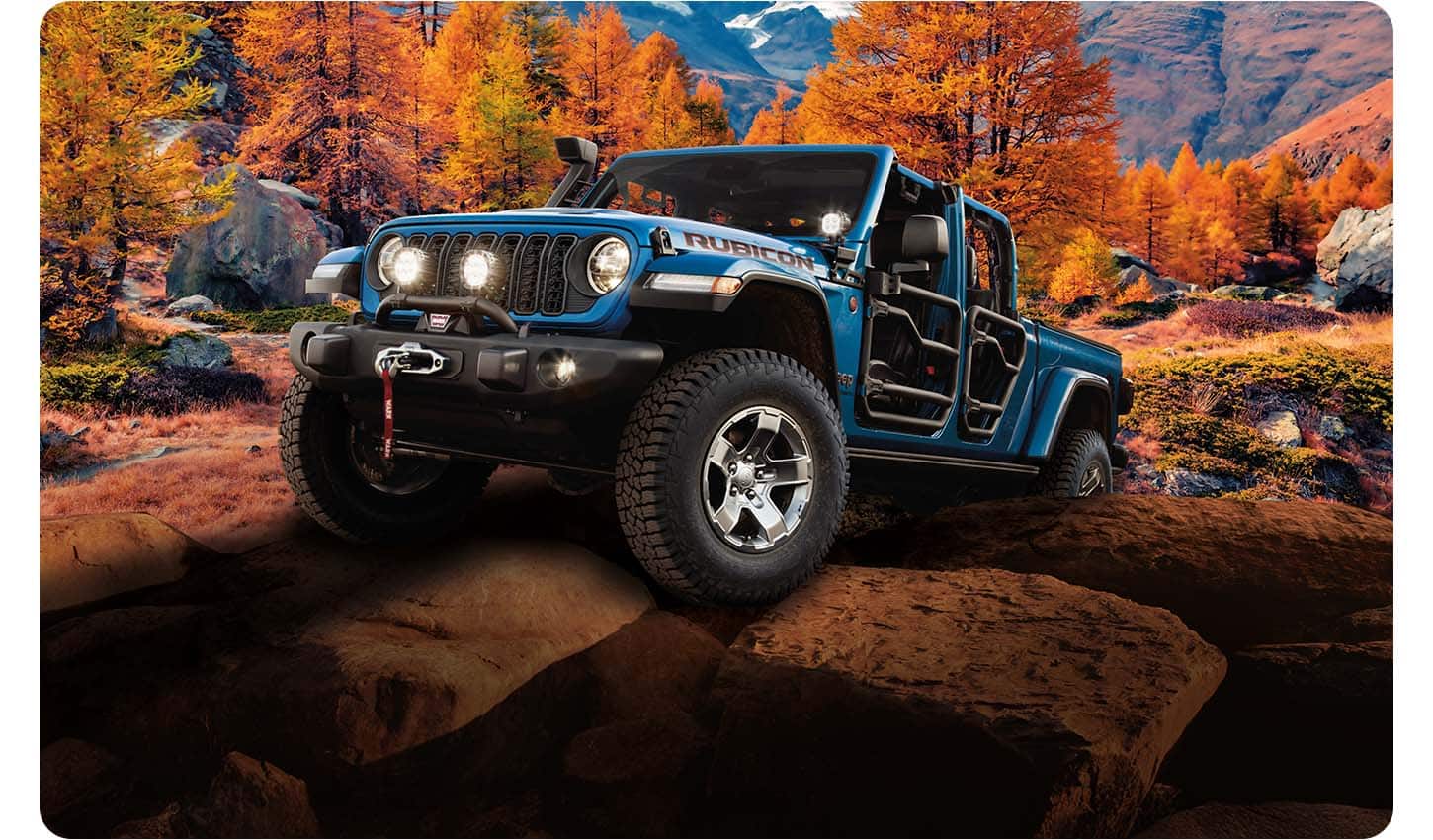 A blue 2026 Jeep Gladiator Rubicon with tube doors, crawling up a rocky hill, off-road in the mountains.