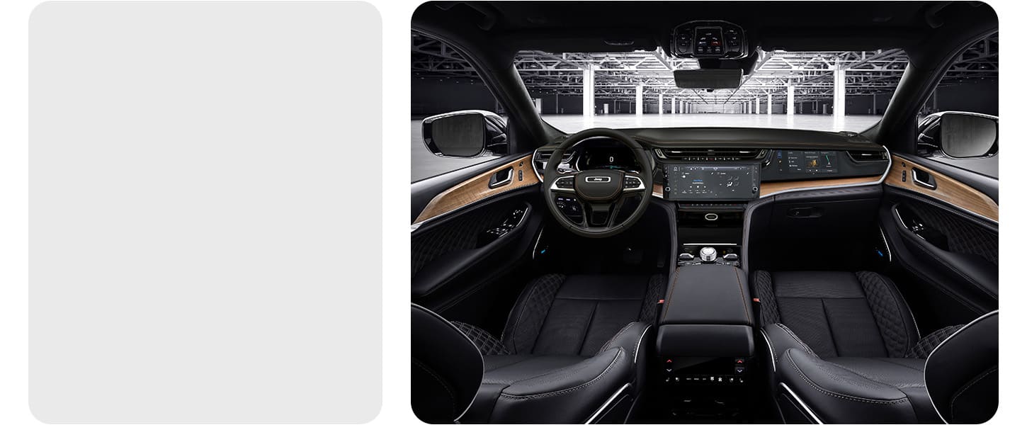 The interior of a 2026 Jeep Grand Cherokee Summit focusing on the front seats, steering wheel, Uconnect touchscreen, Front Passenger Interactive Display and center console controls.