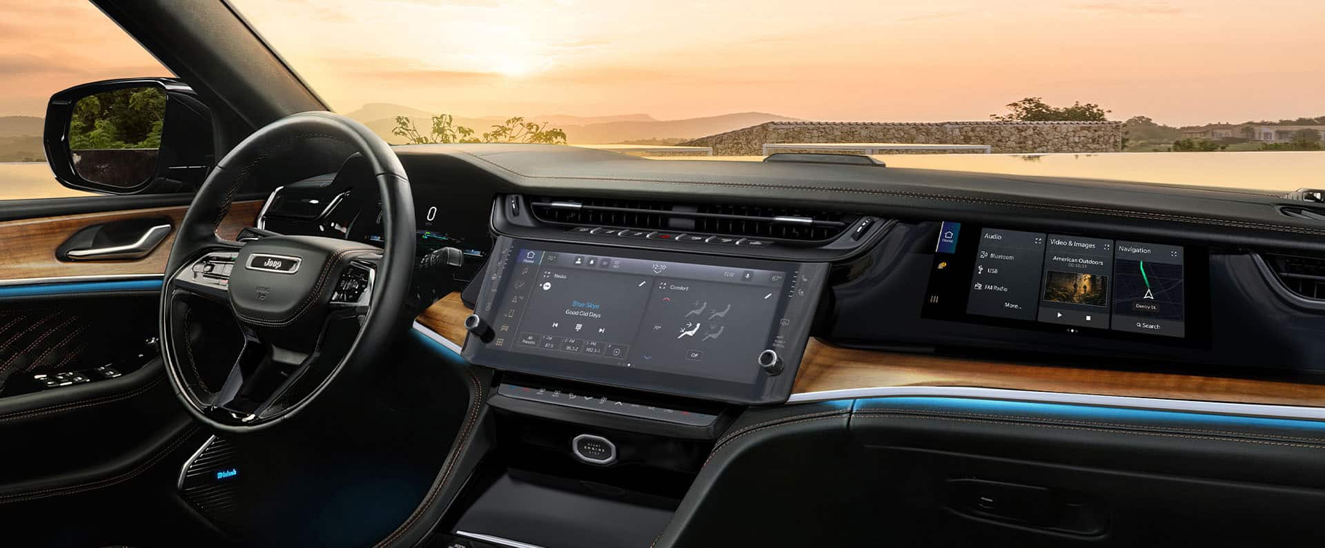 The steering wheel, Uconnect touchscreen, Front Passenger Interactive Touchscreen Display and wireless charging pad in the 2026 Jeep Grand Cherokee Summit.