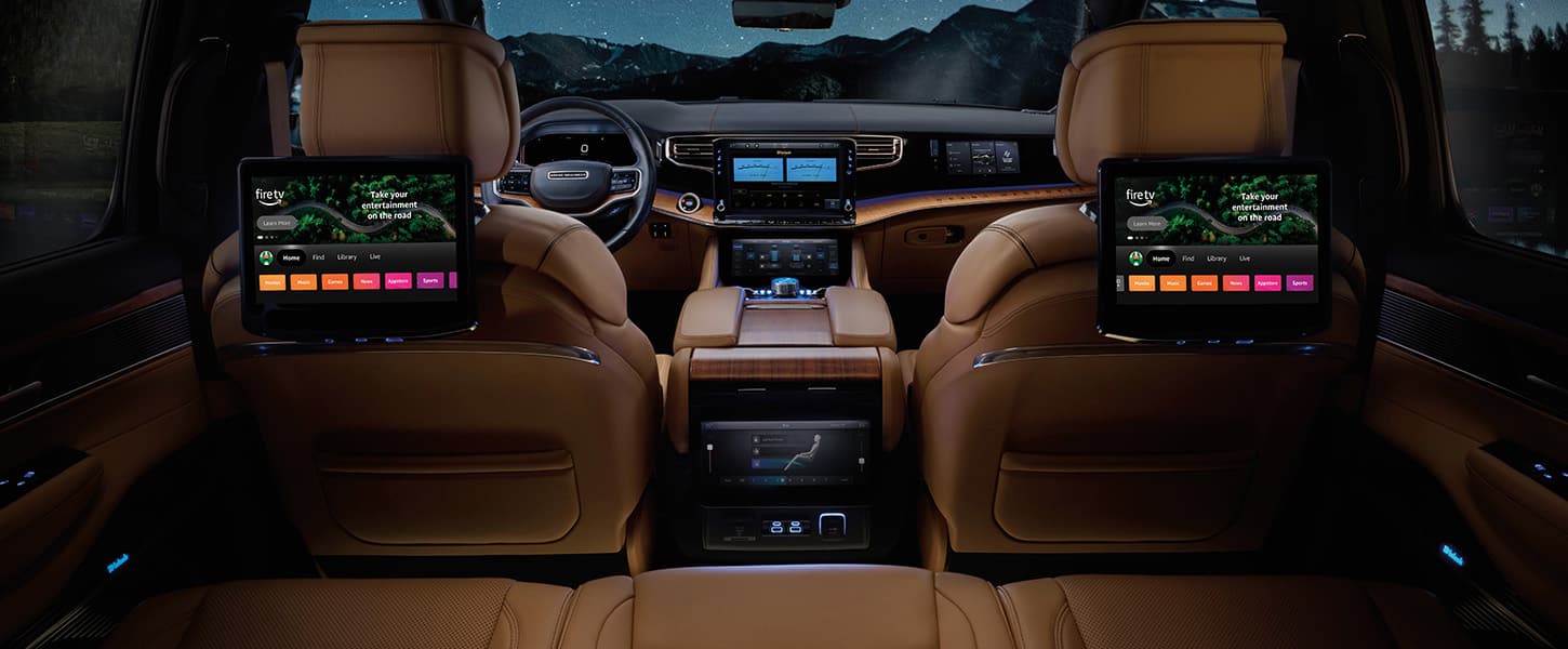 The second row of the 2026 Jeep Grand Wagoneer Summit Reserve with the two front seatback-mounted touchscreens displaying Amazon Fire TV selections.