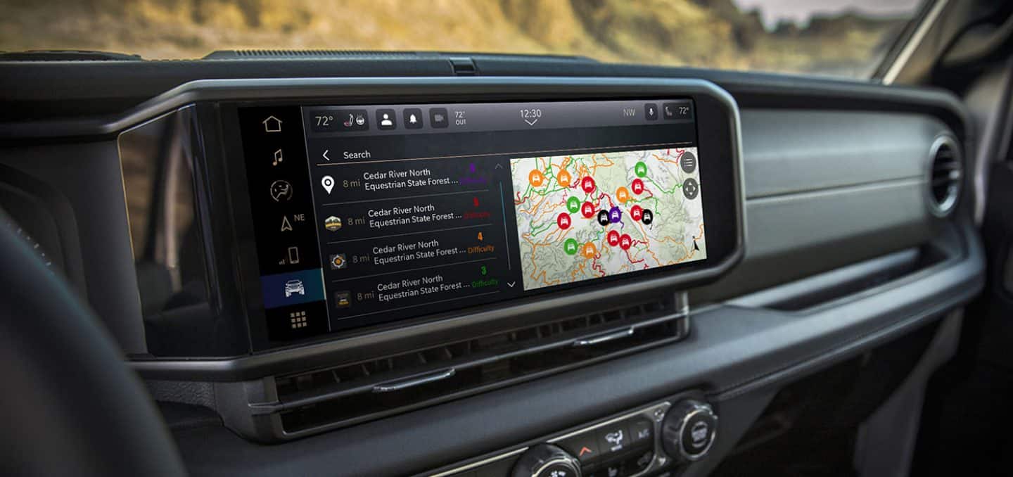 Display The Uconnect touchscreen in a 2026 Jeep Wrangler displaying a page in the Off-Road Trail Guide from Trails Offroad.