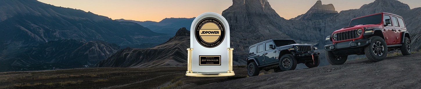 Two 2026 Jeep Wrangler four-door models on a hill off-road in the mountains. On the left a blue Wrangler Rubicon and on the right, a red Wrangler Rubicon. Best Residual Value Among Compact SUVs in 2026. JD Power U.S. ALG Residual Value Award—Compact SUV 2026 Presented To Jeep Wrangler By JD Power.