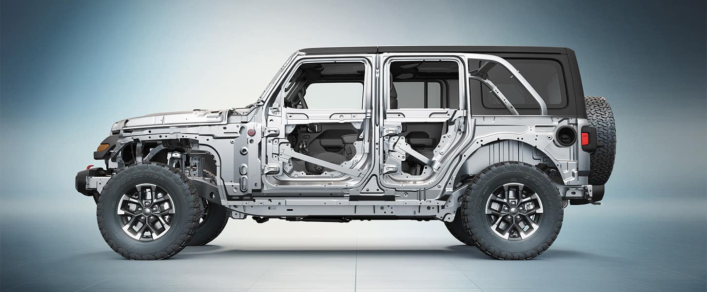 A driver-side profile under-the-skin of the steel frame on a 2026 Jeep Wrangler.
