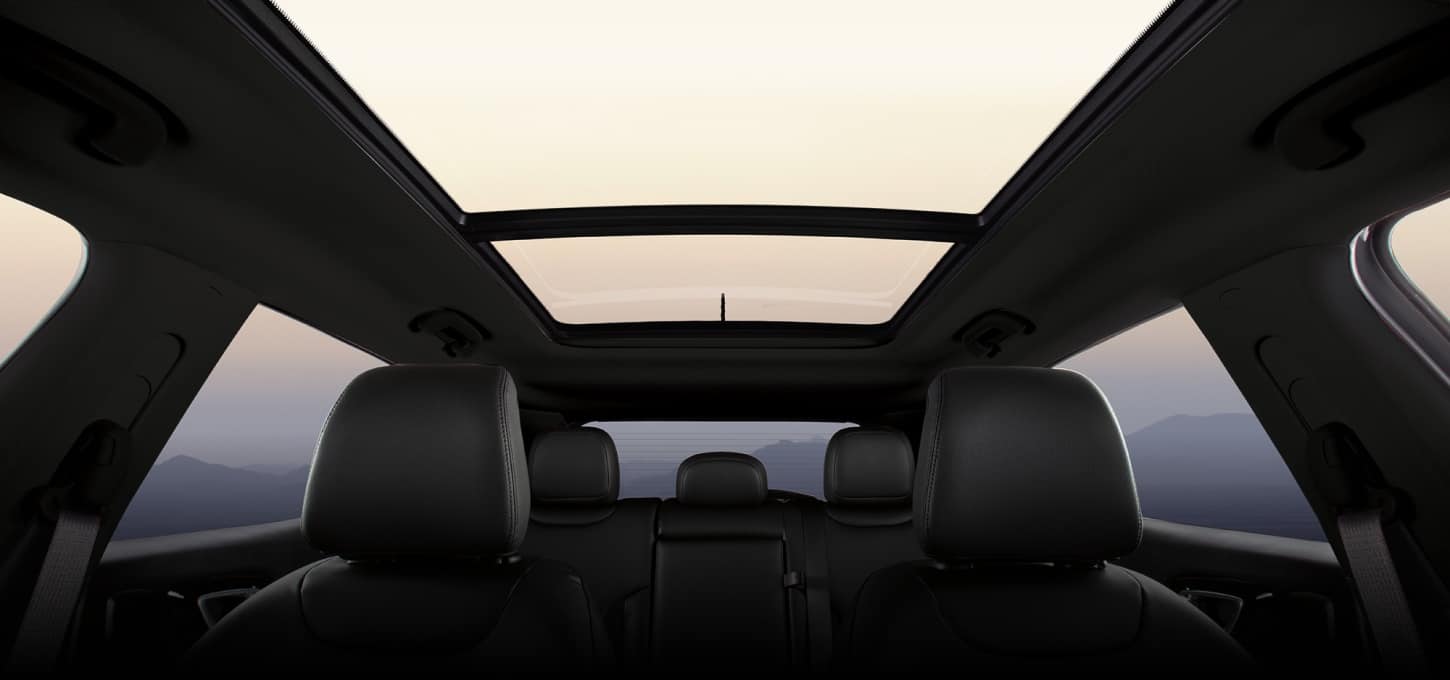 Low-angle interior view of the 2027 Jeep Compass taken inside the front of the vehicle, showing off sunroof and windows.