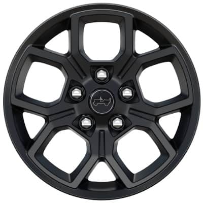 A close-up shot of a 17-Inch painted black aluminum wheel on a 2027 Jeep Gladiator Willys.