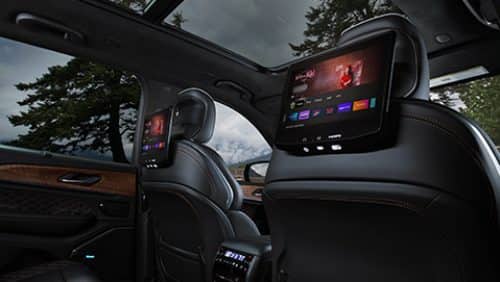 The seatback-mounted touchscreens in the second row of the 2027 Jeep Grand Cherokee Summit displaying Amazon Fire TV selections.