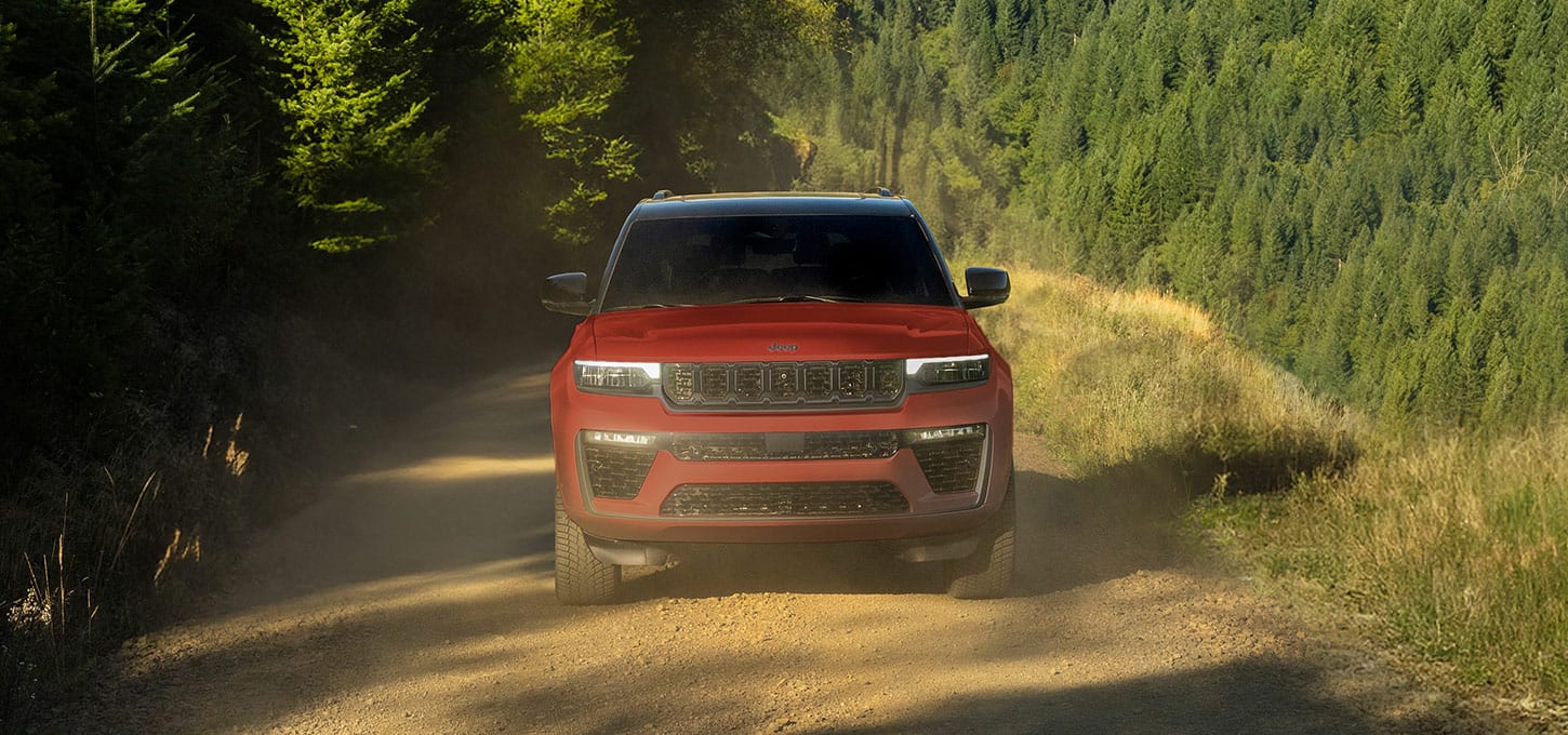 Red Jeep Grand Cherokee on a forest trail