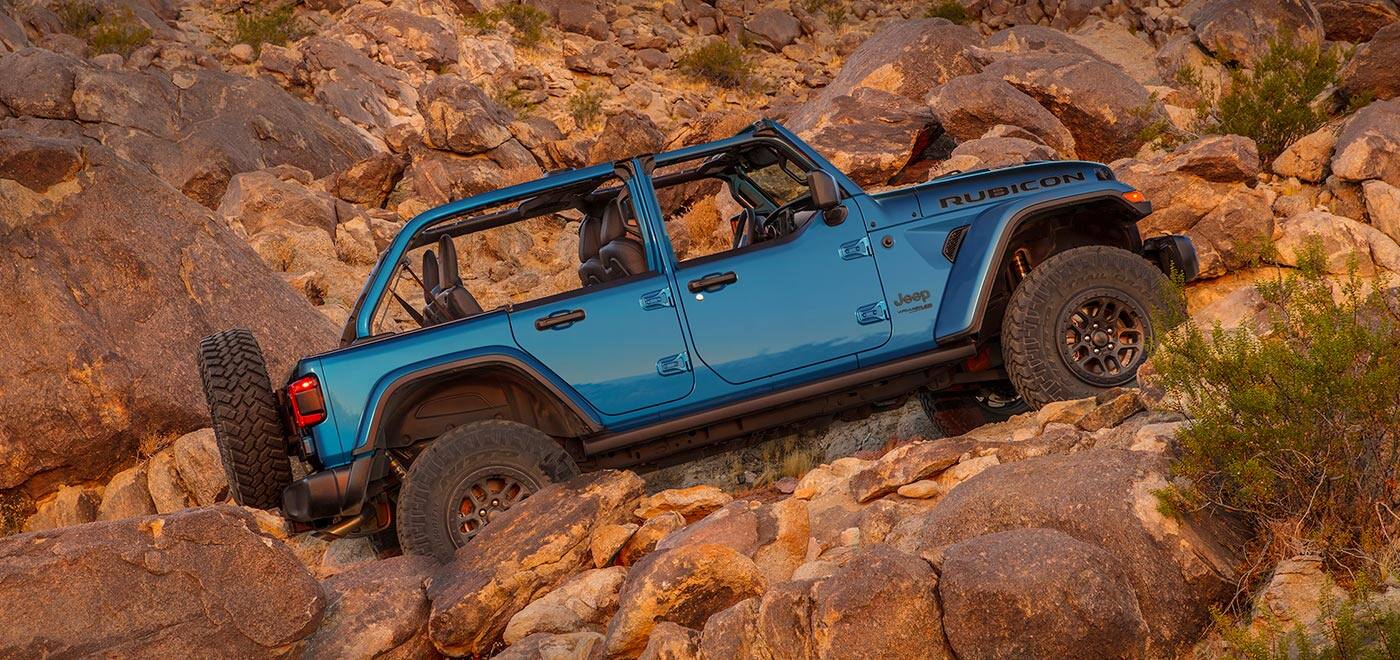 The 2021 Jeep Wrangler Rubicon 392 with half doors, parked facing uphill on a steep, rocky slope.