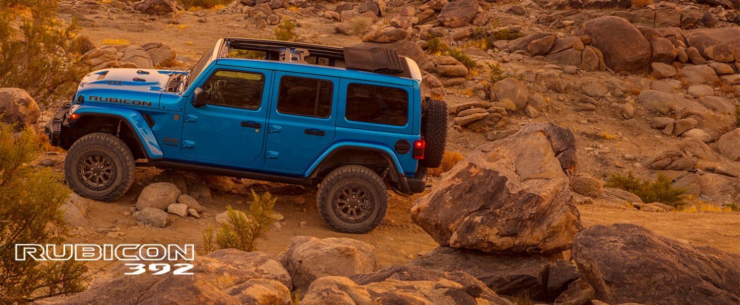 The 2021 Jeep Wrangler Rubicon 392 parked on rocky desert terrain with its Sky One-Touch Power Top opened.