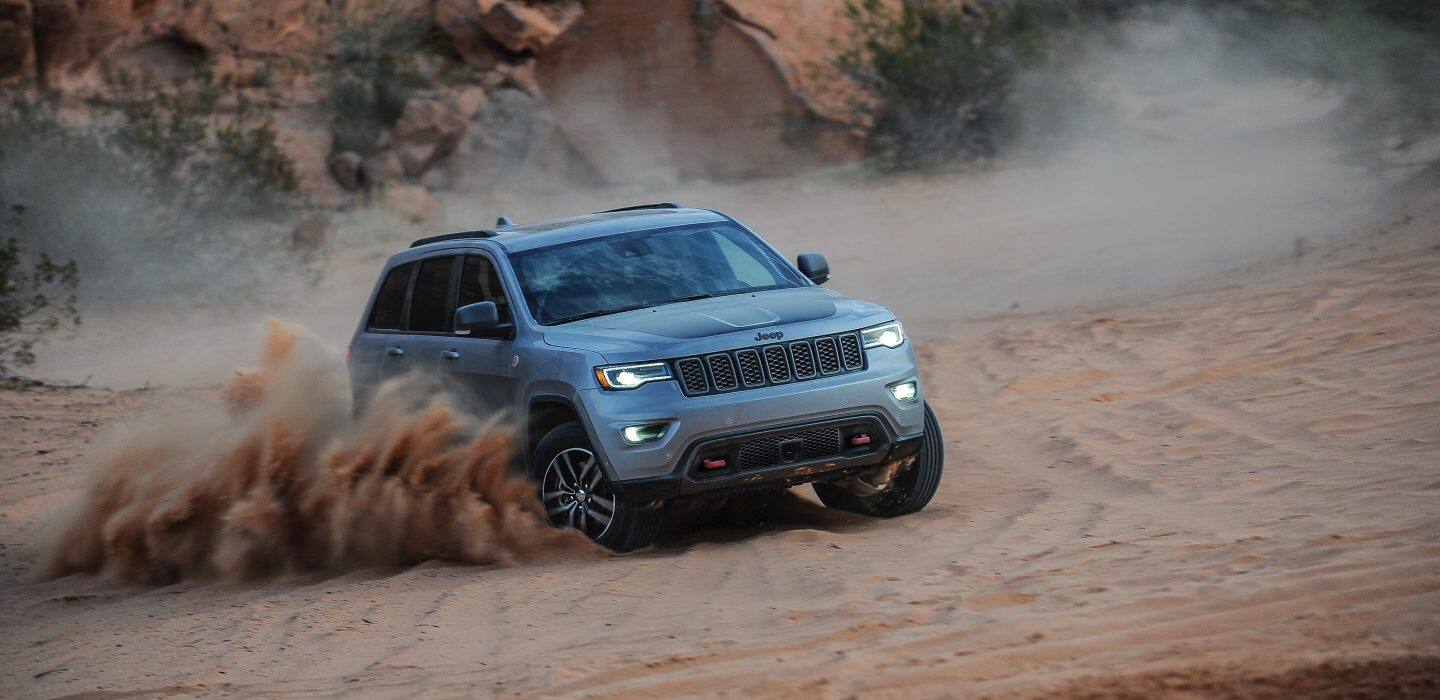 Jeep Grand Cherokee Trailhawk being driven on sandy terrain.