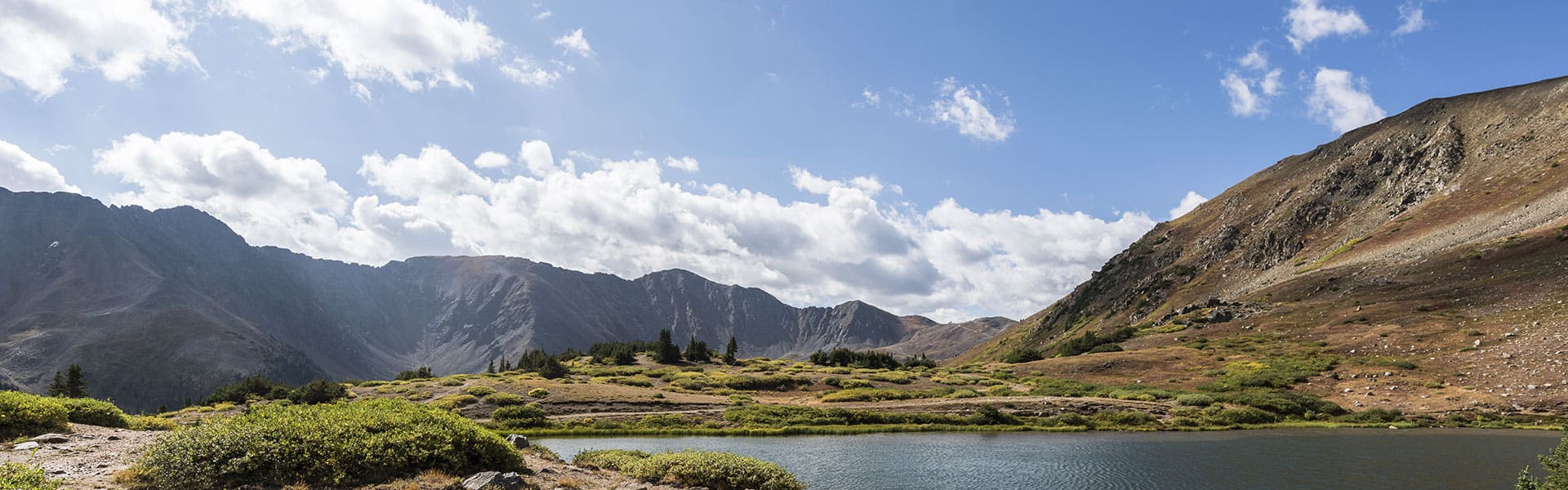 A lakeside view of a mountain range.