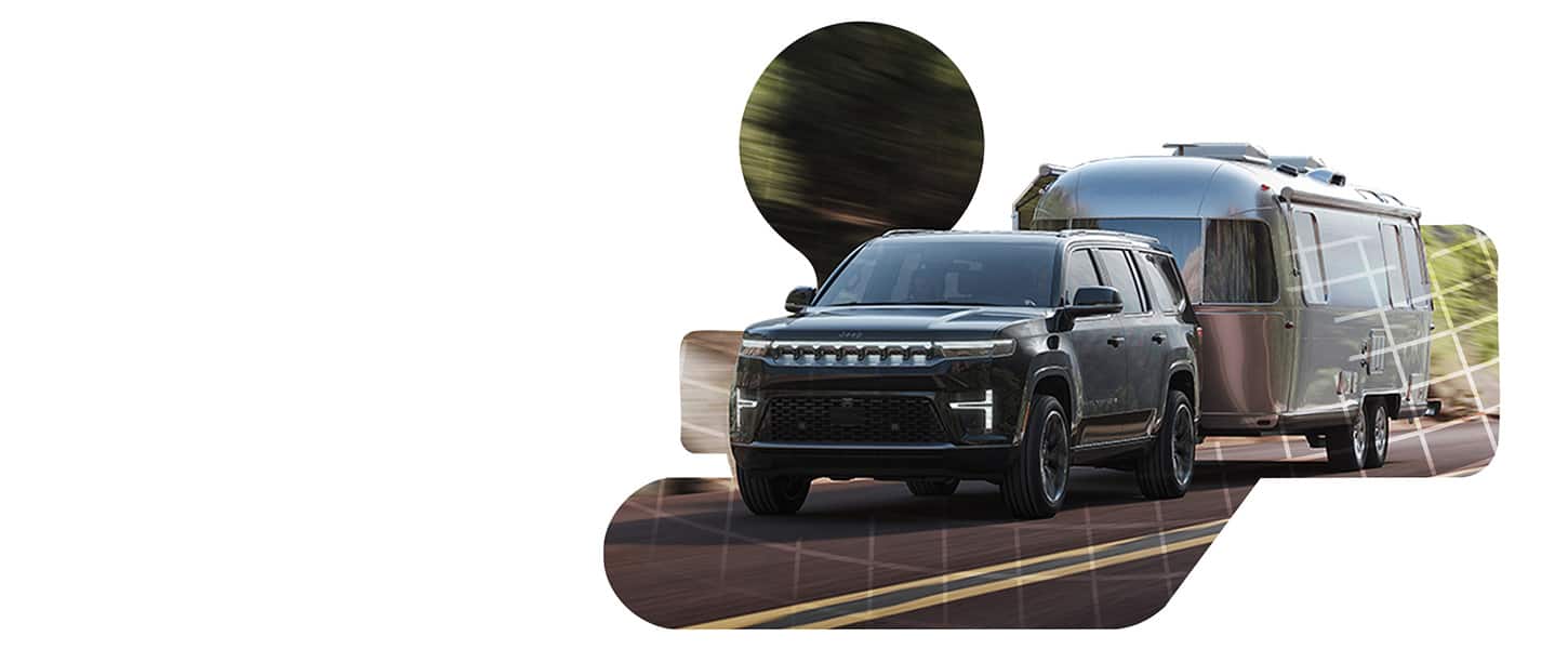 A black Jeep Grand Wagoneer Summit Obsidian traveling down a highway, towing a travel trailer.