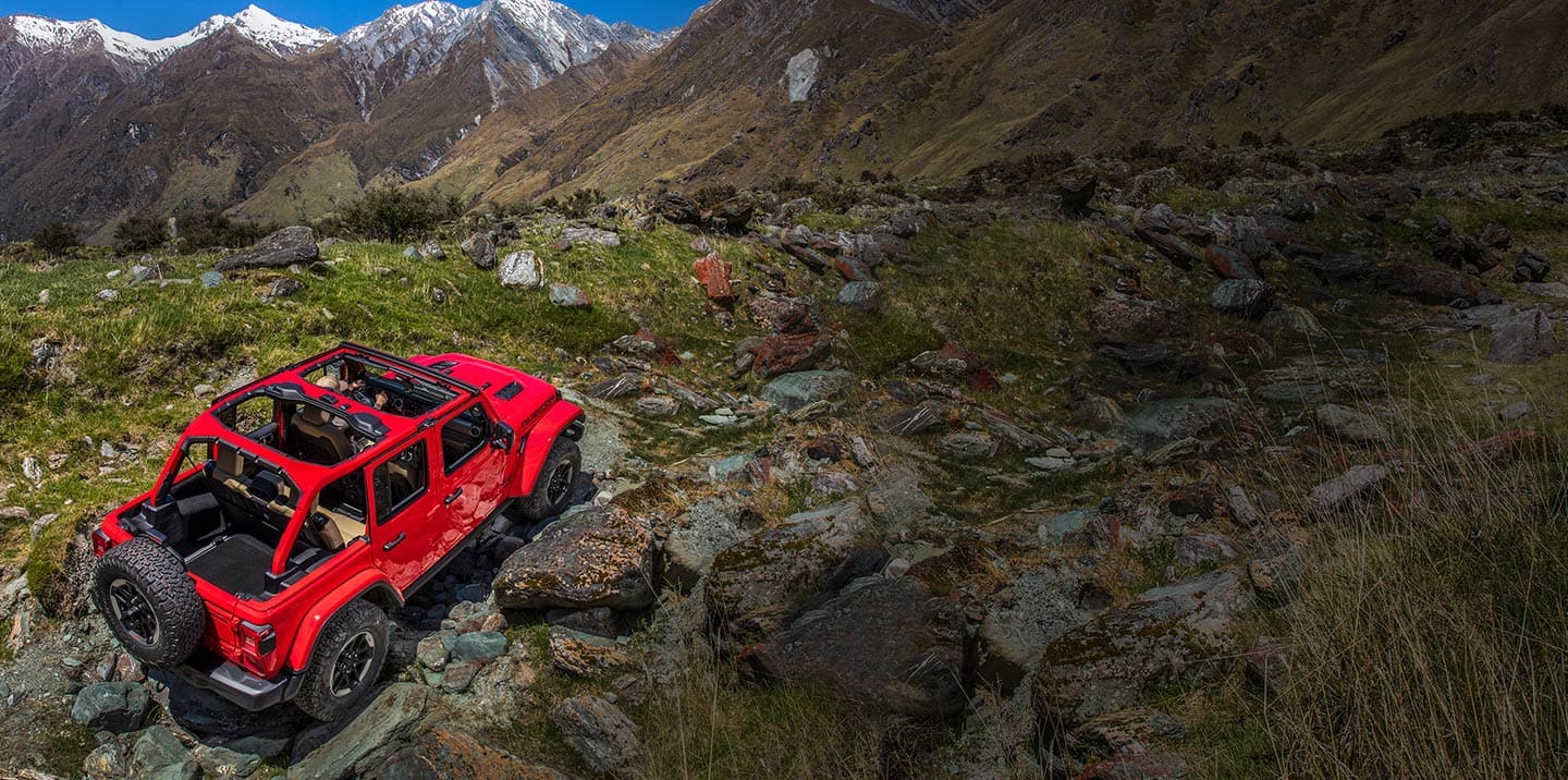 Jeep Wrangler Rubicon andando por un terreno rocoso y montañoso.