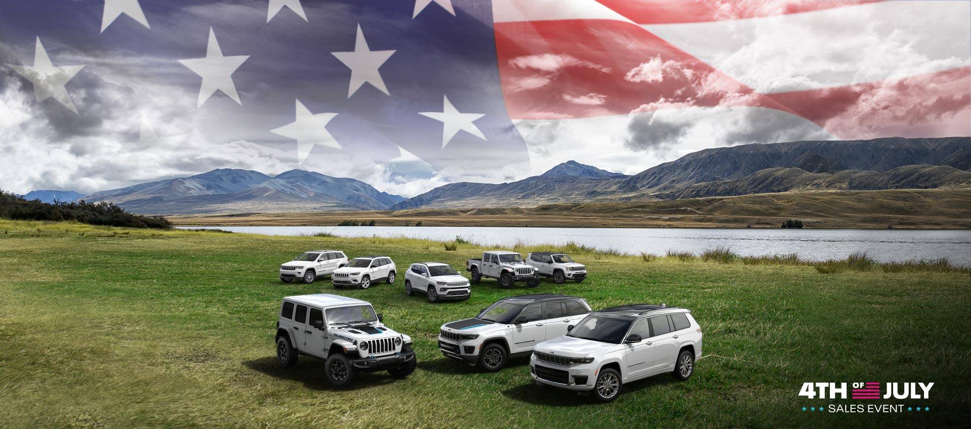 The 2022 Jeep Brand lineup parked beside a lake with mountains and an overlay of the American flag in the background. Front row: the Wrangler Unlimited Rubicon 4xe, Grand Cherokee 4xe Trailhawk and Grand Cherokee L. Back row: Grand Cherokee WK Limited, Cherokee Limited, Compass Limited, Gladiator Rubicon and Renegade Limited. The 4th of July Sales Event Logo.