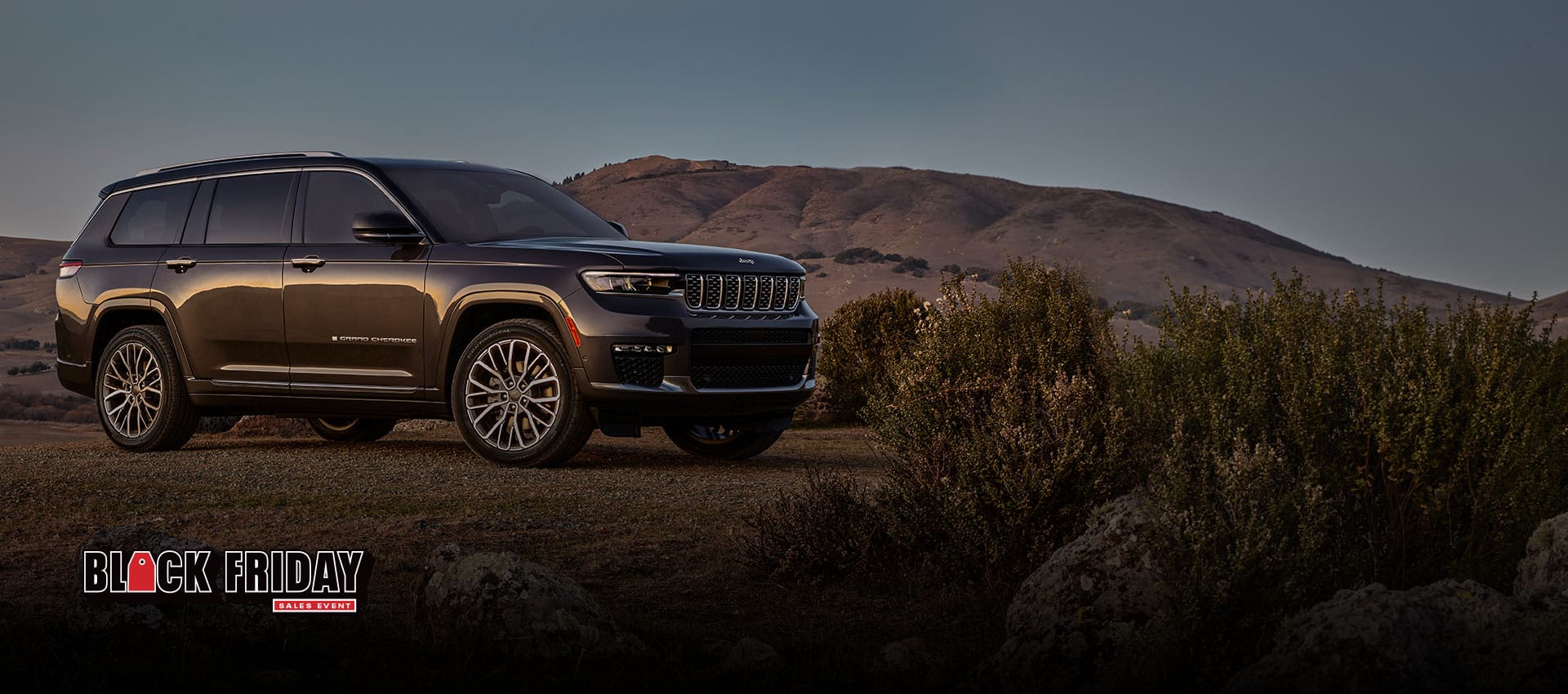 The 2023 Jeep Grand Cherokee Summit Reserve parked in a desert setting. The Black Friday Sales event logo.