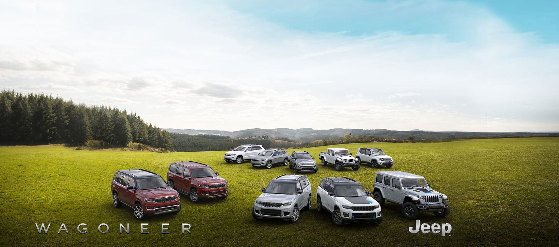 A lineup of eight 2022 Jeep Brand vehicles and two 2022 Wagoneer Brand vehicles on a grassy plain with mountains rising in the distance.