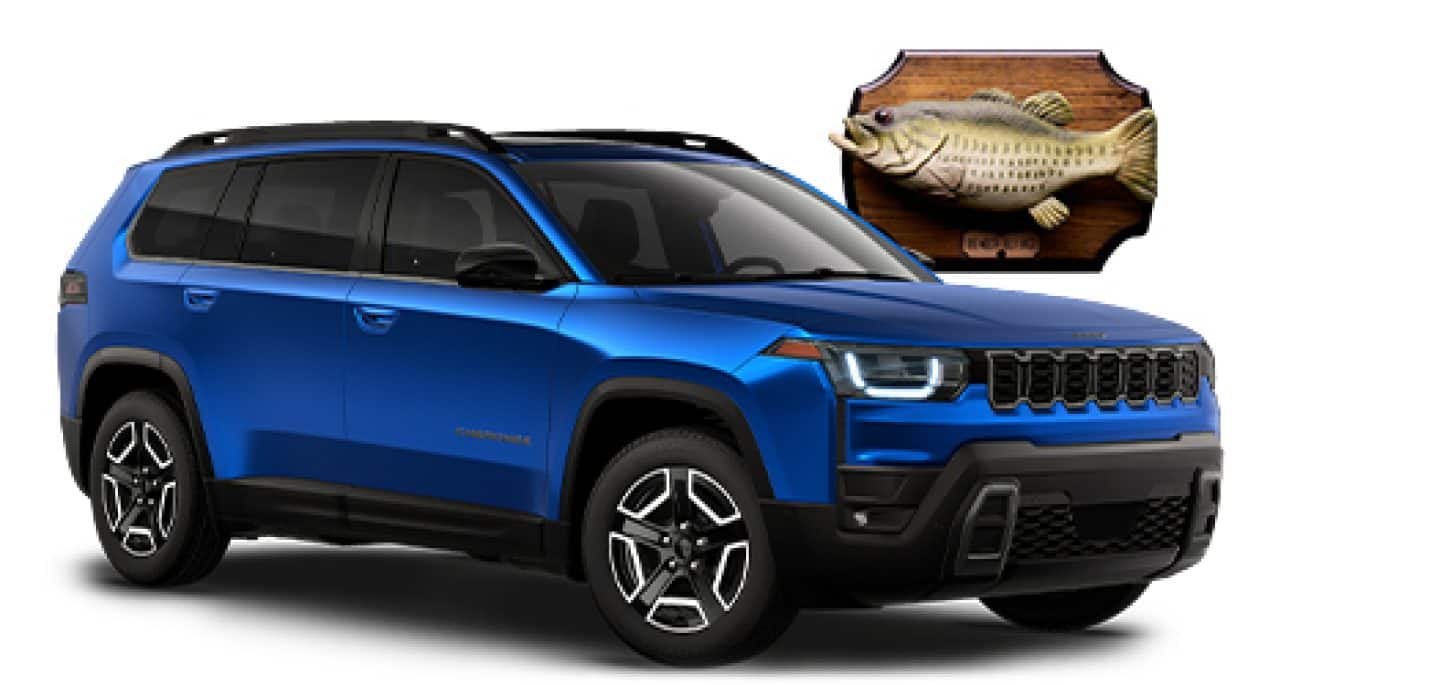 A passenger-side front angle of a blue 2026 Jeep Cherokee Laredo along with a Billy Bass wall mount.