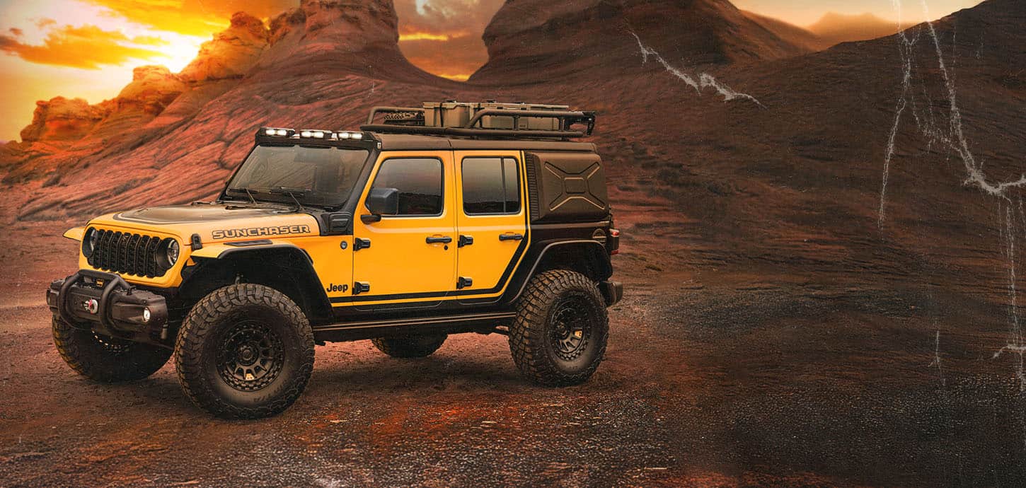 Ángulo delantero del lado del conductor del vehículo Jeep Wrangler 4xe Suncatcher estacionado en el desierto, al atardecer.