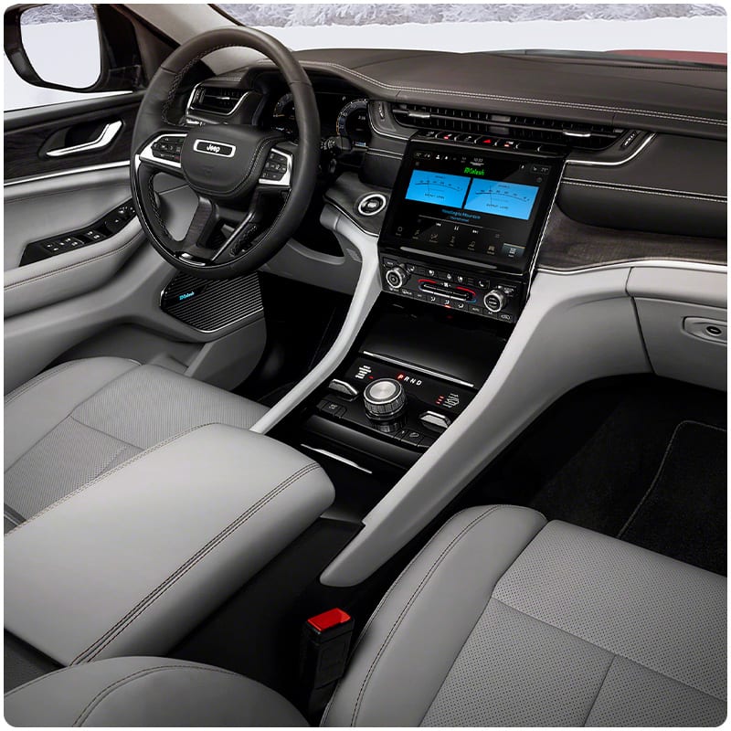 The interior of the 2021 Jeep Grand Cherokee L focusing on the front-row seats and dashboard.