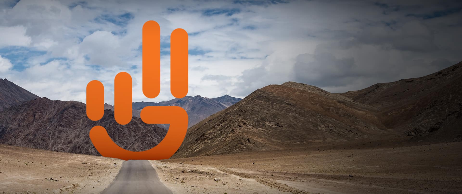Jeep Wave logo superimposed on an open road leading to the mountains.