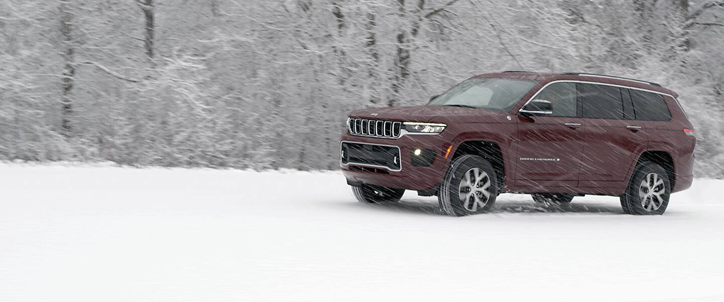 The 2021 Jeep Grand Cherokee Overland being driven off-road in a snow storm.