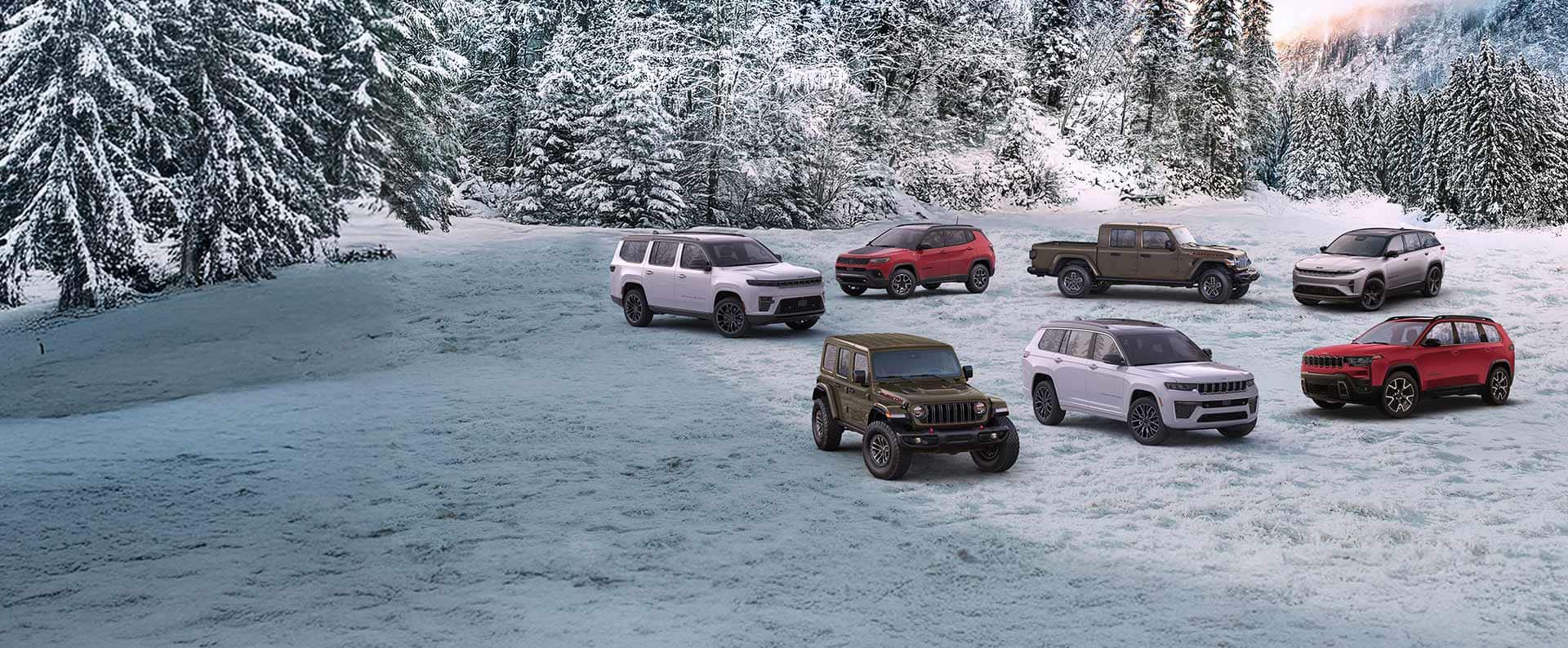 A lineup of seven 2026 Jeep Brand vehicles parked on a snow-covered clearing with a forest in the background. In the front row: an olive drab Wrangler Rubicon X, a white Grand Cherokee Summit and a red Cherokee Overland. In the back row: a white Grand Wagoneer Summit Obsidian, a red Compass Trailhawk, an olive drab Gladiator Mojave X and a silver 2025 Wagoneer S Launch Edition.
